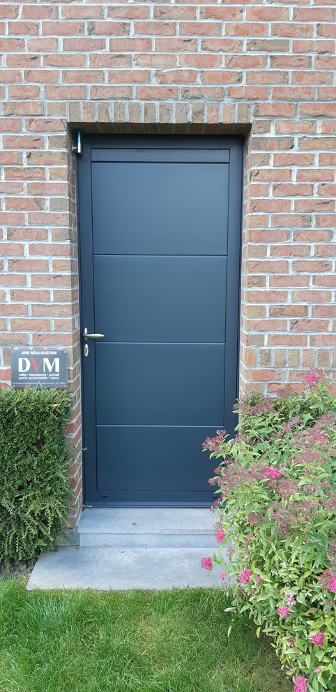 Porte de service en panneaux de porte sectionnelle rappelant la porte de garage gris 7016