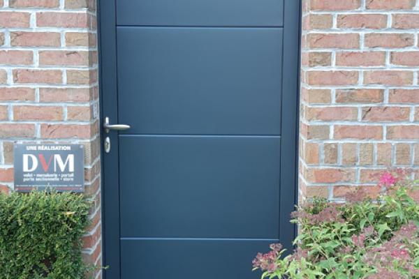 Porte de service en panneaux de porte sectionnelle rappelant la porte de garage gris 7016